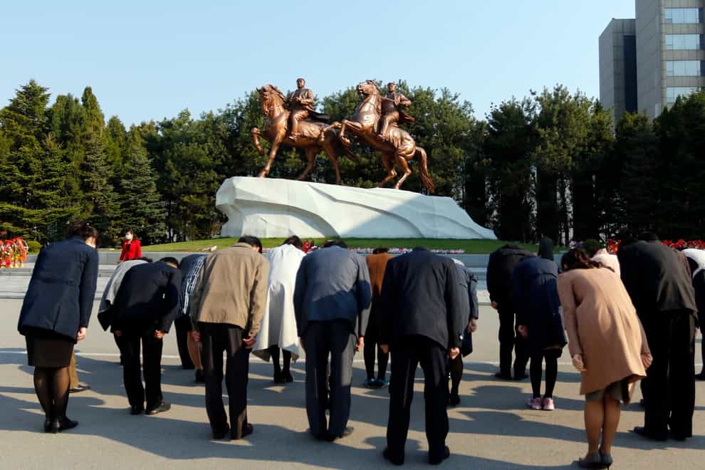 People pay tribute at the statues of North Korean leaders Kim Il Sung and Kim Jong Il (Jon Chol Jin/AP)