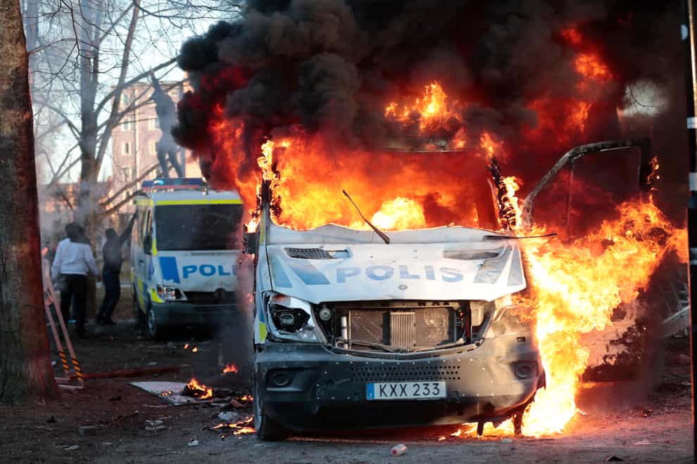 Protesters set fire to a police bus in the park Sveaparken in Orebro, Sweden (TT via AP)