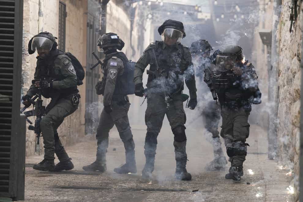 Palestinians shoot fireworks at Israeli police in the Old City of Jerusalem (Mahmoud Illean/AP)