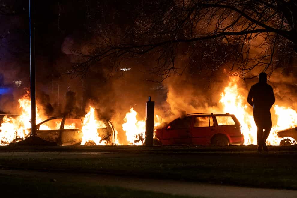 Cars are engulfed by flames after protests broke out in Malmo (Johan Nilsson/TT via AP)
