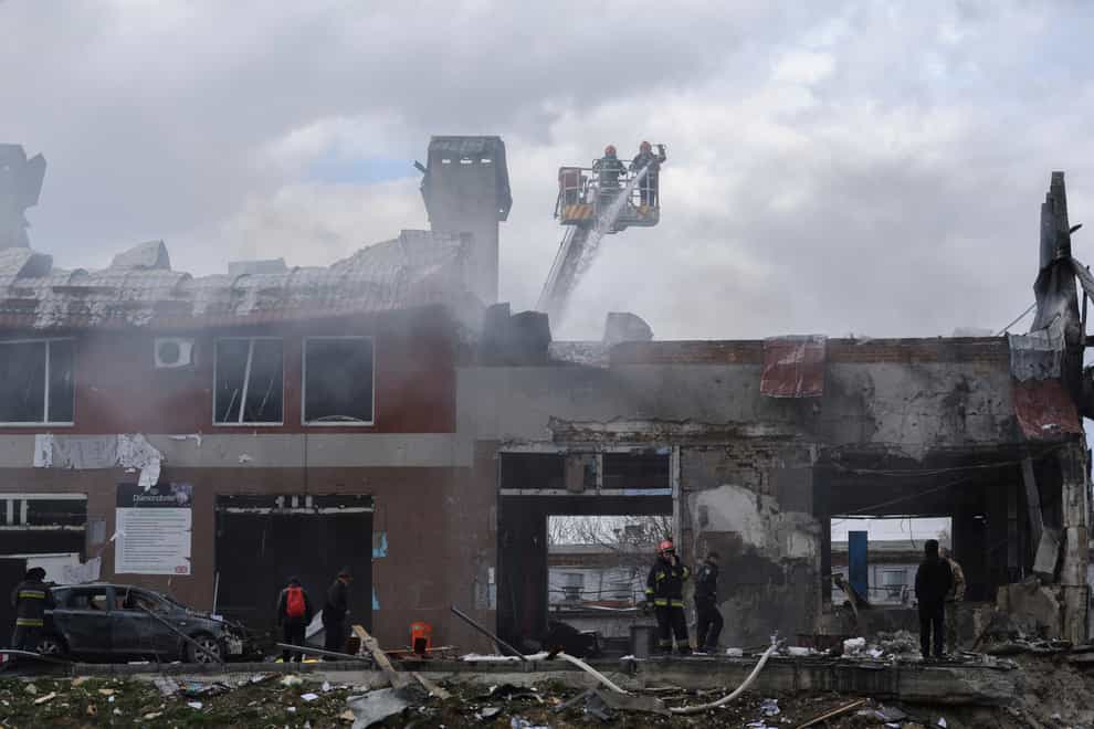 Firefighters work to extinguish a fire after an air strike hit a tyre shop in Lviv, Ukraine (Mykola Tys/AP)