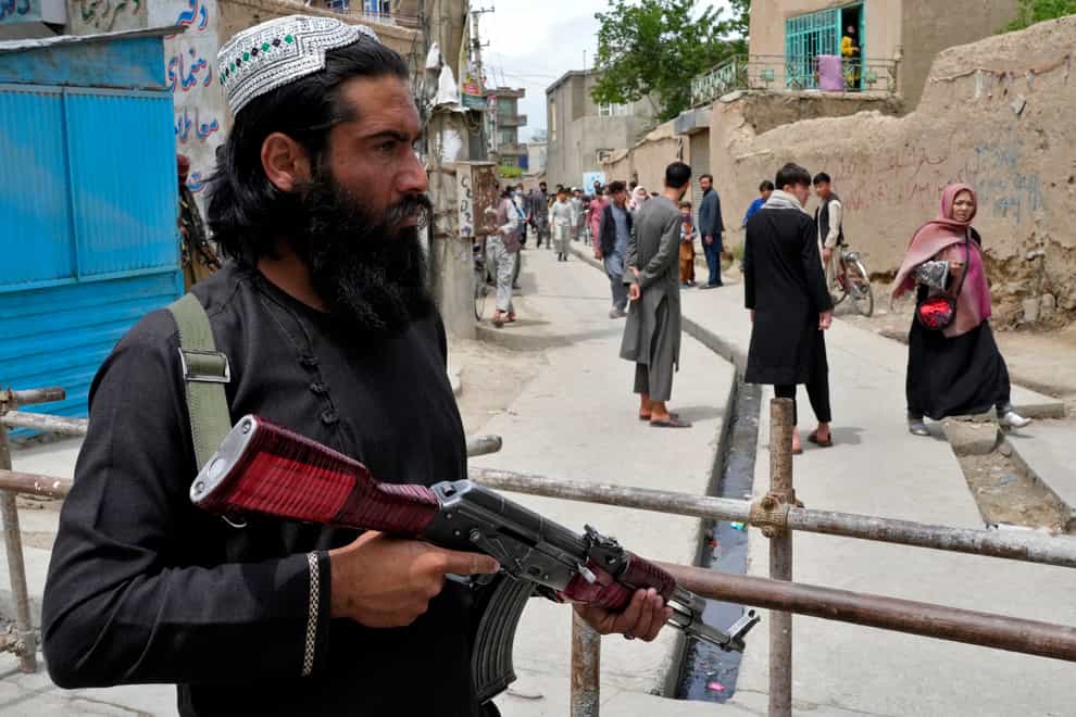 A Taliban fighter stands guard at the site of an explosion in front of a school, in Kabul, Afghanistan, Tuesday, April 19, 2022. An Afghan police spokesman says explosions targeting educational institutions in Kabul have killed at least six civilians and injured over 10 others. Khalid Zadran said Tuesday the blasts occurred in the mostly-Shiite Muslim area in the west of Afghanistan’s capital. (AP Photo/Ebrahim Noroozi)