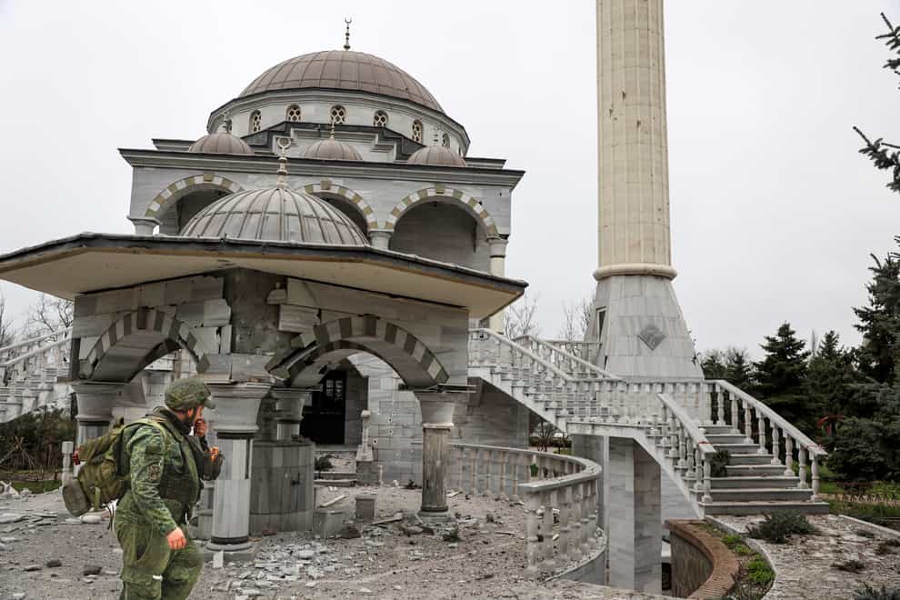 A serviceman of Donetsk People’s Republic militia walks past a damaged mosque in an area controlled by Russian-backed separatist forces in Mariupol (AP Photo/Alexei Alexandrov)