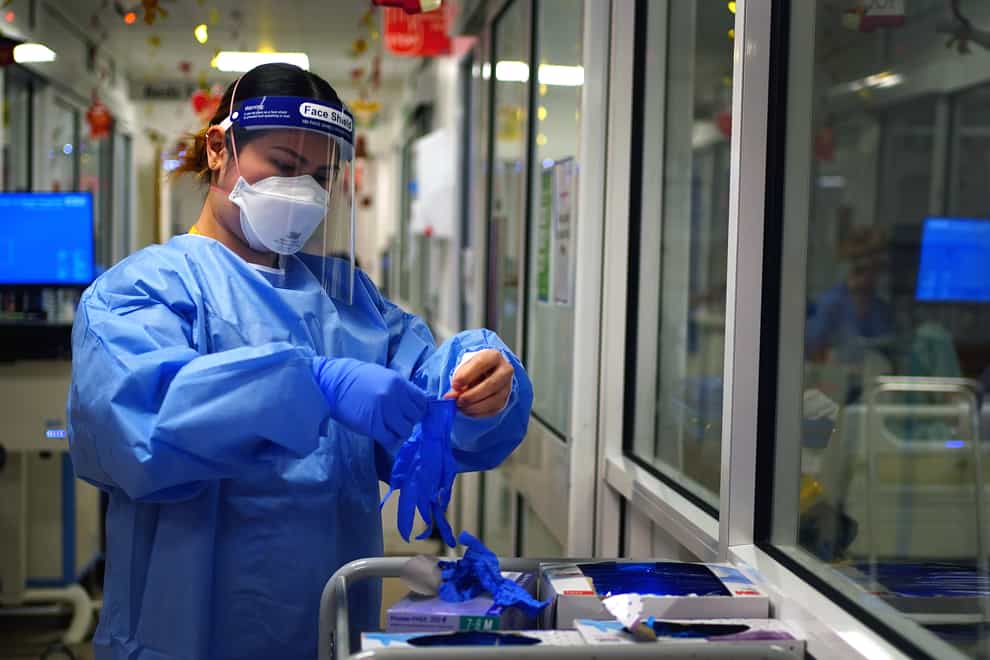 A nurse puts on PPE in a ward for Covid patients (Victoria Jones/PA)