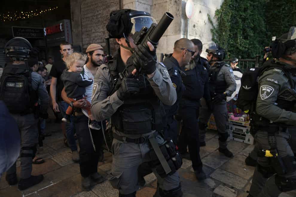 Israeli security forces escort a group of Jews outside Damascus Gate, in Jerusalem’s Old City, on Wednesday April 20 2022 (Mahmoud Illean/AP)