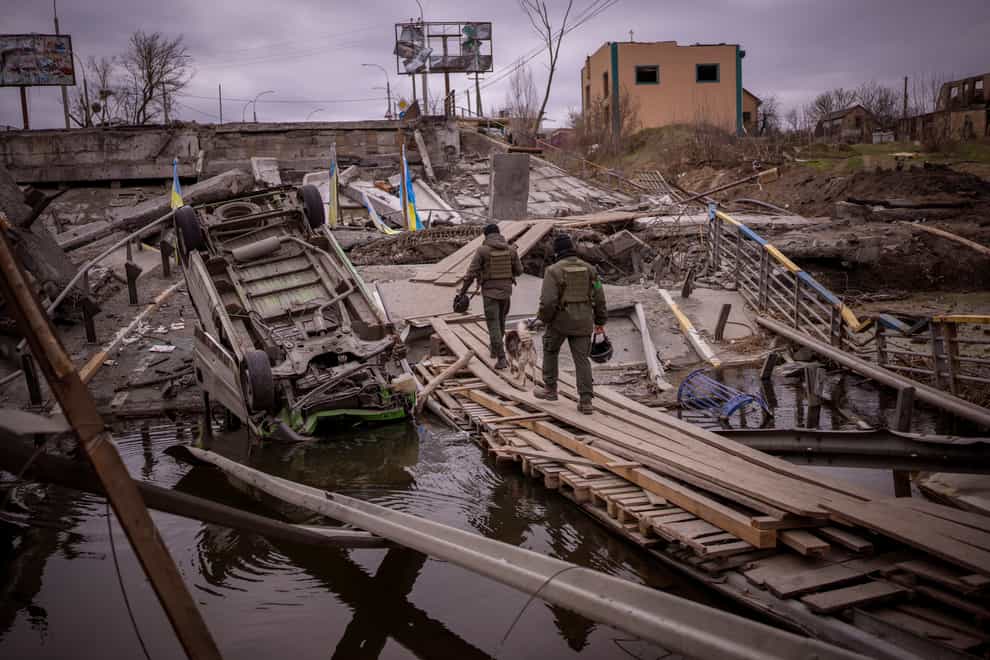 Ukrainian soldiers walk on a destroyed bridge in Irpin, on the outskirts of Kyiv, on Wednesday April 20 2022 (Emilio Morenatti/AP)