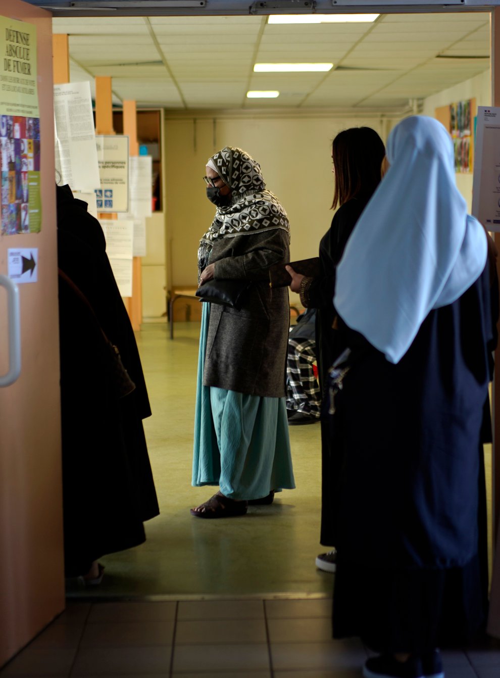 Women wait in line before voting for the first round of the presidential election at a polling station on Sunday April 10 in the Malpasse northern district of Marseille, southern France (Daniel Cole/AP)
