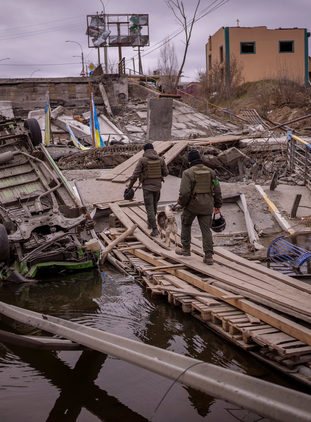 Ukrainian soldiers walk on a destroyed bridge in Irpin, on the outskirts of Kyiv (Emilio Morenatti/AP)