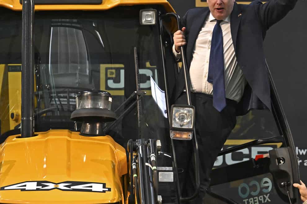 Prime Minister Boris Johnson waves from a JCB at the new JCB Factory in Vadodara, Gujarat, during his two day trip to India (Ben Stansall/PA)