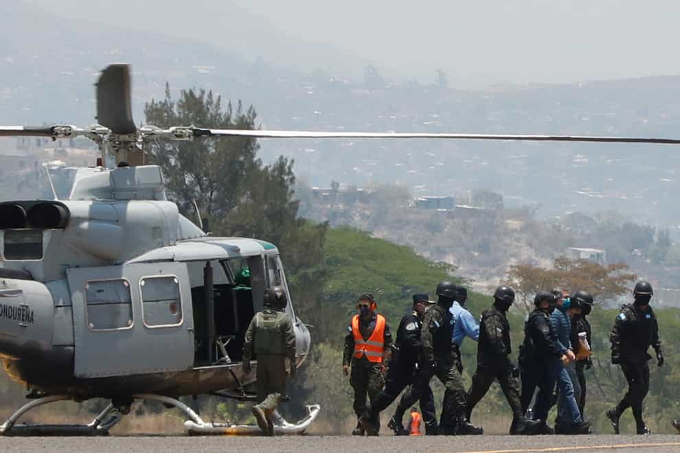Former Honduran president Juan Orlando Hernandez in handcuffs at an air base in Tegucigalpa (Elmer Martinez/AP)