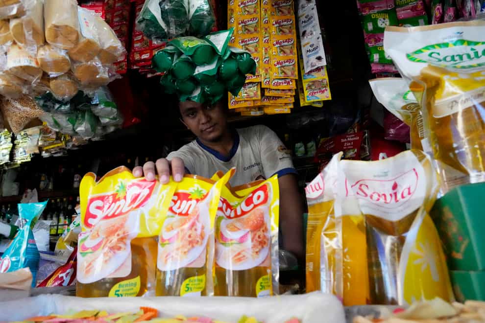 A vendor shows packs of cooking oil at his stall at a market in Jakarta, Indonesia (Achmad Ibrahim/AP)