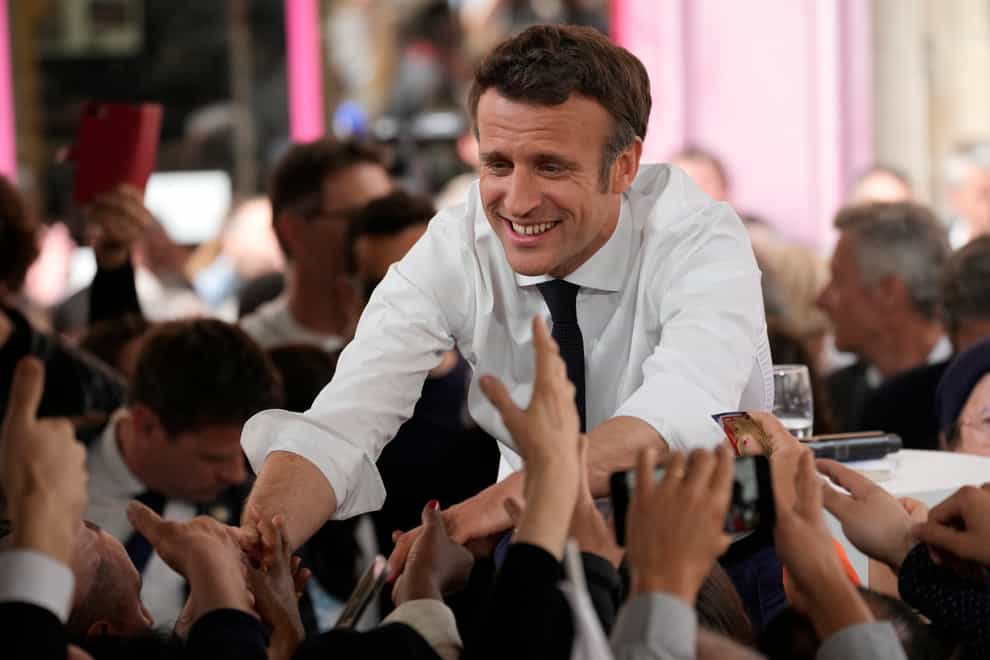 Emmanuel Macron shakes hands with residents after a campaign rally in Figeac, south-western France (AP)