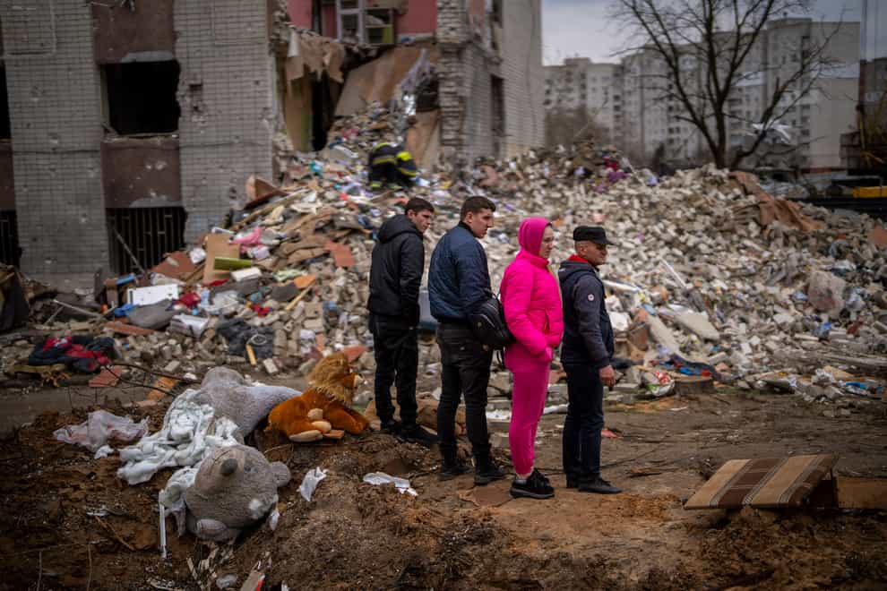 Residents look at their house destroyed by a Russian bomb in Chernihiv (AP)