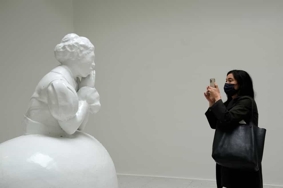 A visitor takes a pictures of the sculpture Anonymous, part of the Sovereignty installation by artist Simone Leigh, at the US pavilion (AP)