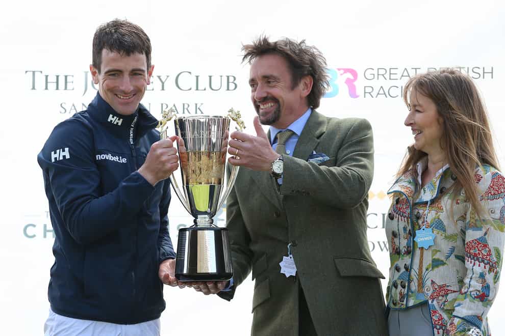 Champion jockey Brian Hughes receives the trophy from Richard and Mindy Hammond (Nigel French/PA)