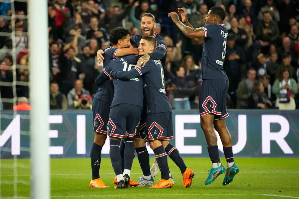 Lionel Messi, number 10, is mobbed by his team-mates after scoring Paris St Germain’s opening goal against Lens (Michel Euler/AP)