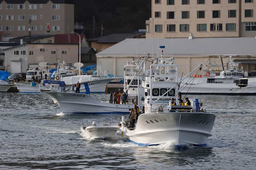 Fishing boats leave a port to search for a missing tour boat in Shari, in the northern island of Hokkaido on Sunday (Kyodo News via AP)