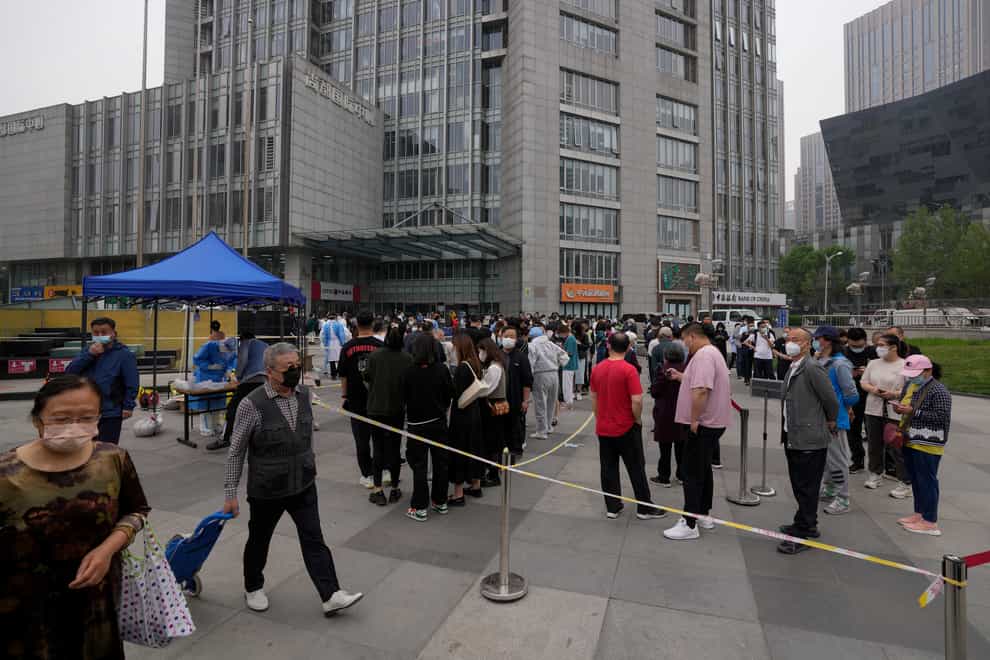 Residents and office workers queue up for coronavirus testing in Beijing’s central business district (Andy Wong/AP)