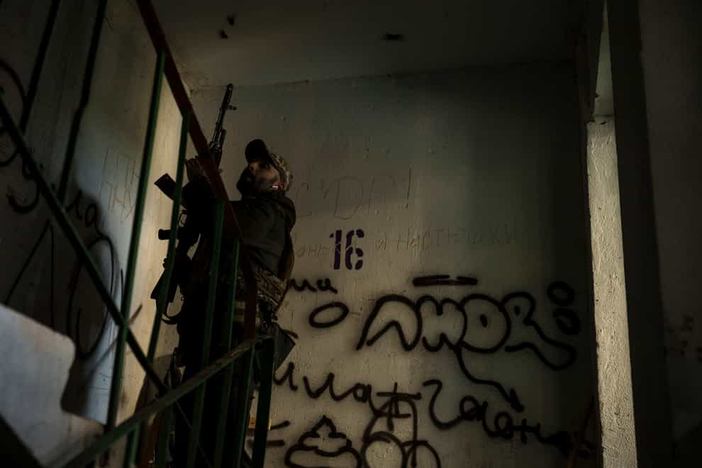 A Ukrainian serviceman walks in a building near a frontline position in Kharkiv, Ukraine (Felipe Dana/AP)