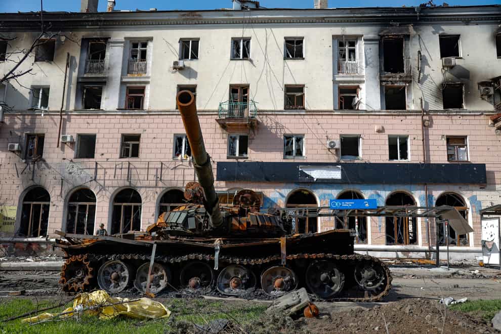 A destroyed tank and a damaged apartment building from heavy fighting are seen in an area controlled by Russian-backed separatist forces in Mariupol (AP)