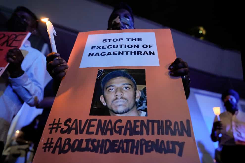 Activists hold posters against the impending execution of Nagaenthran K Dharmalingam (AP)