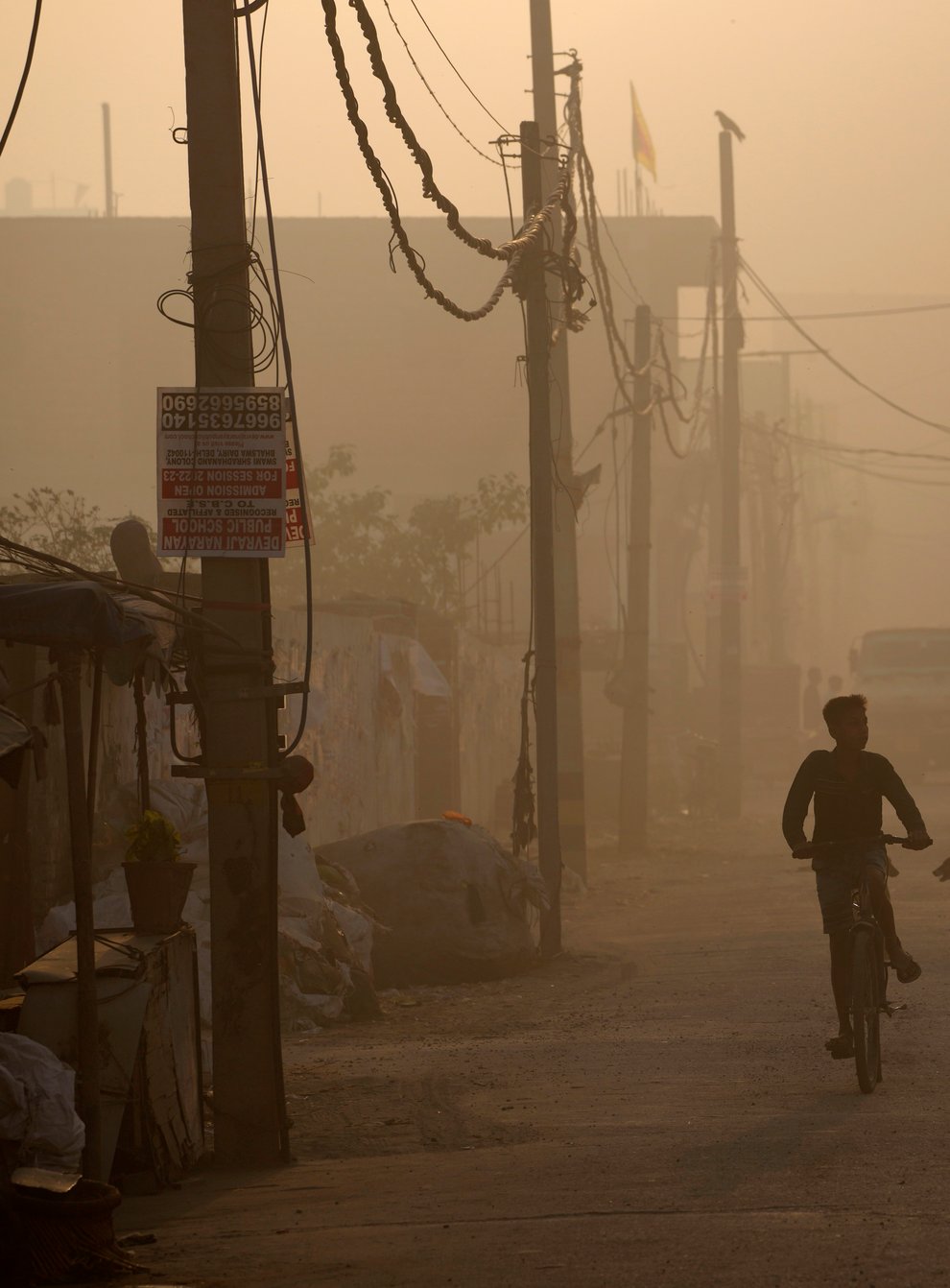 A boy rides a bicycle amidst thick smoke coming out of a fire at the Bhalswa landfill in New Delhi (AP)