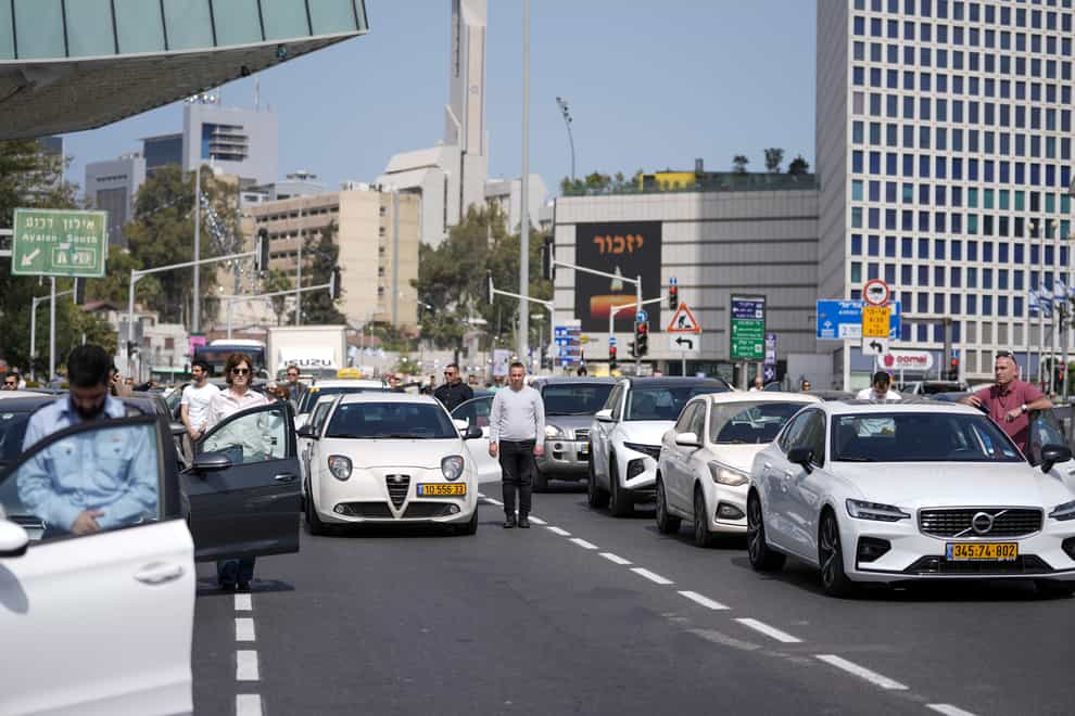 Israelis stand still next to their cars on a main road as a two-minute siren sounds in memory of victims of the Holocaust in Tel Aviv, Israel, on Thursday April 28 2022 (Ariel Schalit/AP)