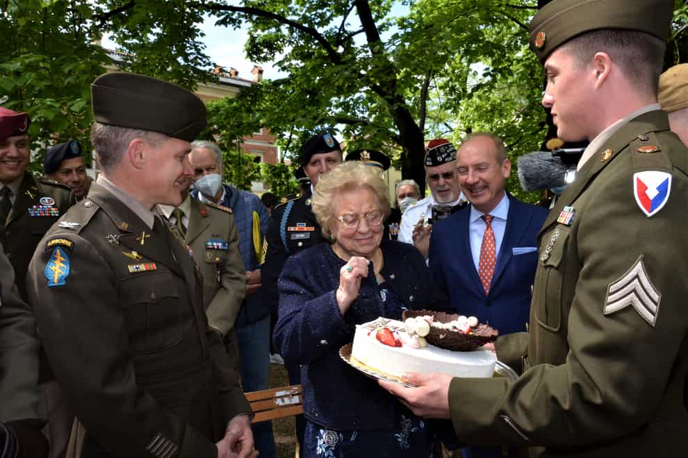 Soldiers from US Army Garrison Italy return a birthday cake to Meri Mion, centre, in Vicenza, northern Italy (Laura Krieder/US Army/AP)