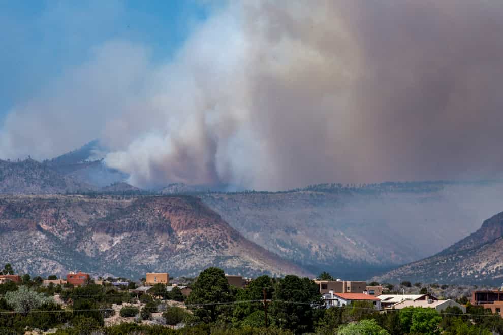More than 1,000 firefighters backed by bulldozers and aircraft were battling the largest active wildfire in the US after strong winds pushed it across some containment lines (Robert Browman//The Albuquerque Journal/AP)