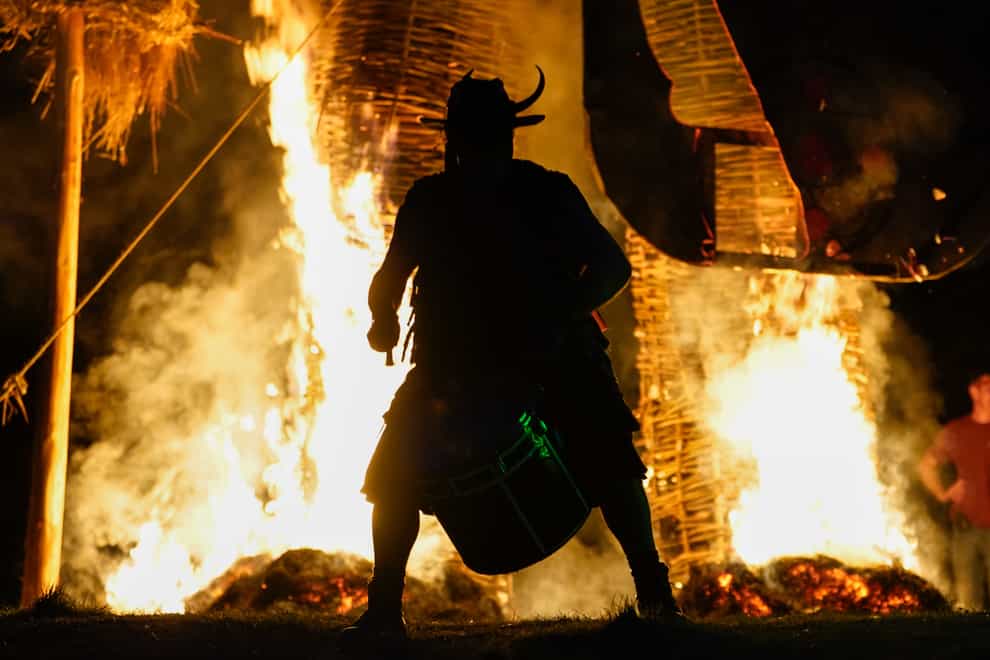 A member of the Pentacle Drummers performs in front of a burning wicker man during the Beltane Festival at Butser Ancient Farm, in Waterlooville, Hampshire (Andrew Matthews/PA)