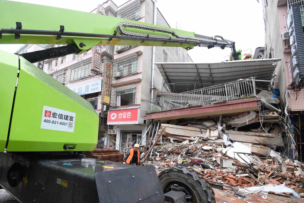 Rescue workers on a crane over the collapsed residential building in Changsha (Shen Hong/Xinhua via AP)
