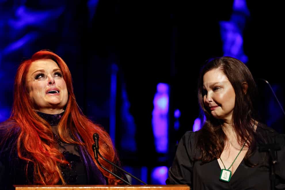 Wynonna Judd, left, looks to the sky as sister Ashley Judd watches during the medallion ceremony at the Country Music Hall of Fame in Nashville, Tennessee (Wade Payne/Invision/AP)