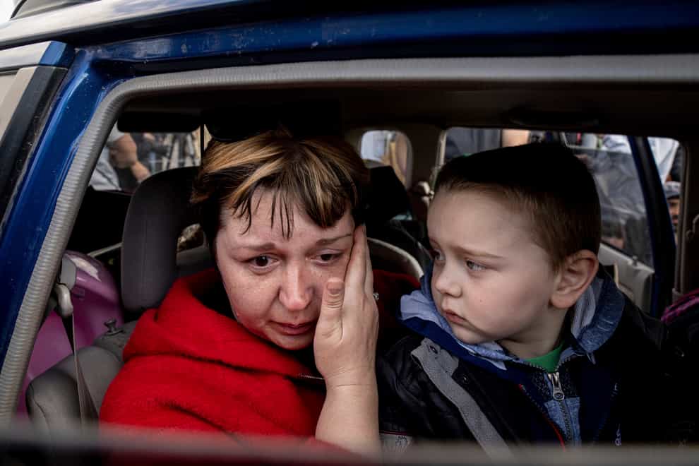 Natalia Pototska, 43, cries as her grandson Matviy looks on in a car at a centre for displaced people in Zaporizhzhia, Ukraine, on Monday May 2 2022 (Evgeniy Maloletka/AP)