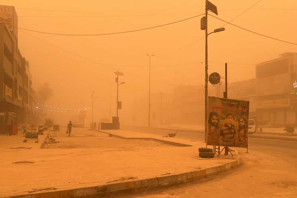 A man walks through a sand storm in Baghdad, Iraq, on Thursday May 5 2022 (Ali Abdul Hassan/AP)