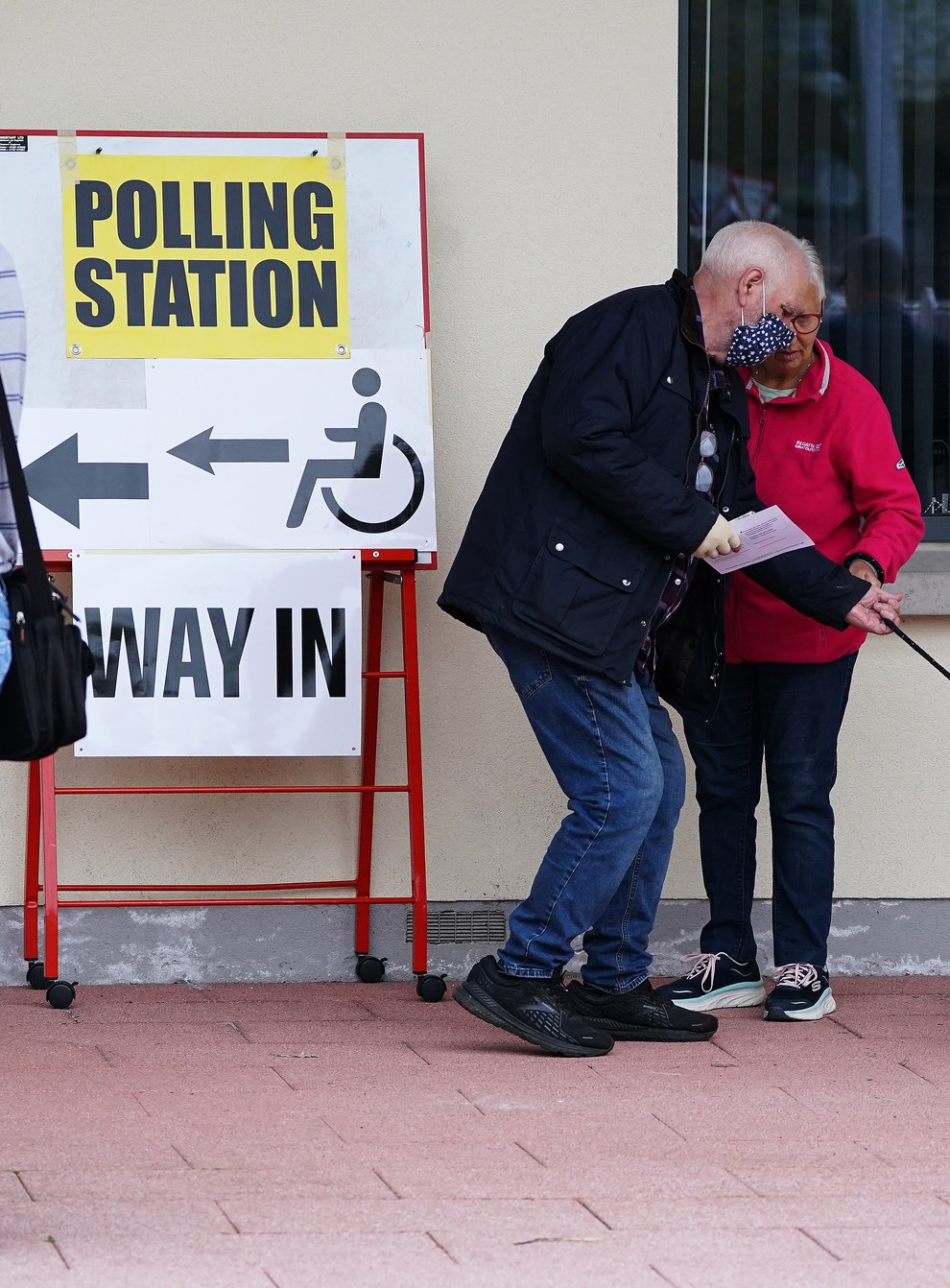 People with a dog outside the polling station in Dromore, Co Down (Brian Lawless/PA)