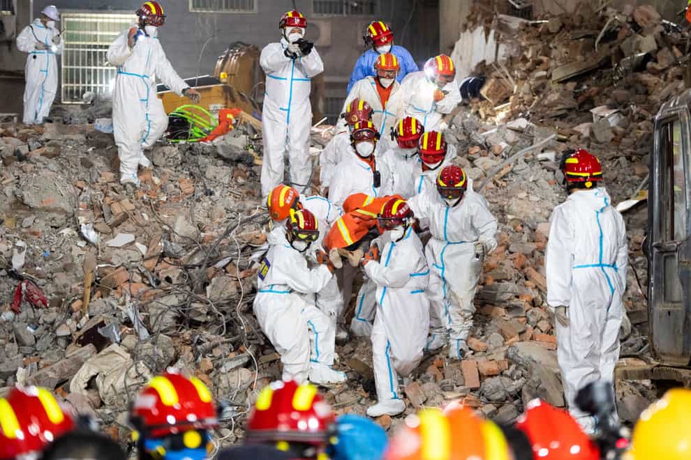 Rescue workers evacuate the 10th survivor, who was trapped for 132 hours from the debris of a self-built residential structure that collapsed in Changsha (Xinhua via AP)