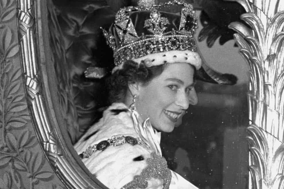 The Queen gives a wide smile for the crowd from her carriage as she leaves Westminster Abbey, London, after her Coronation (PA)