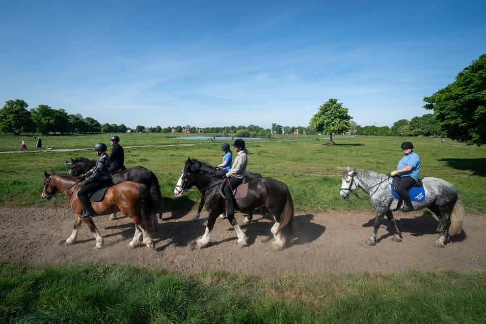 People riding horses along Wimbledon Common in London (Aaron Chown/PA)