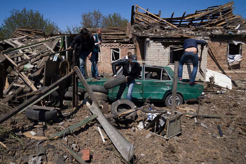 People clean a residential area after a Russian air strike in Bakhmut, Donetsk region, Ukraine (Evgeniy Maloletka/AP)