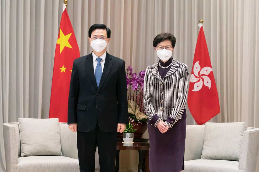 Hong Kong Chief Executive-elect John Lee, left, and Chief Executive Carrie Lam (Pool/AP)