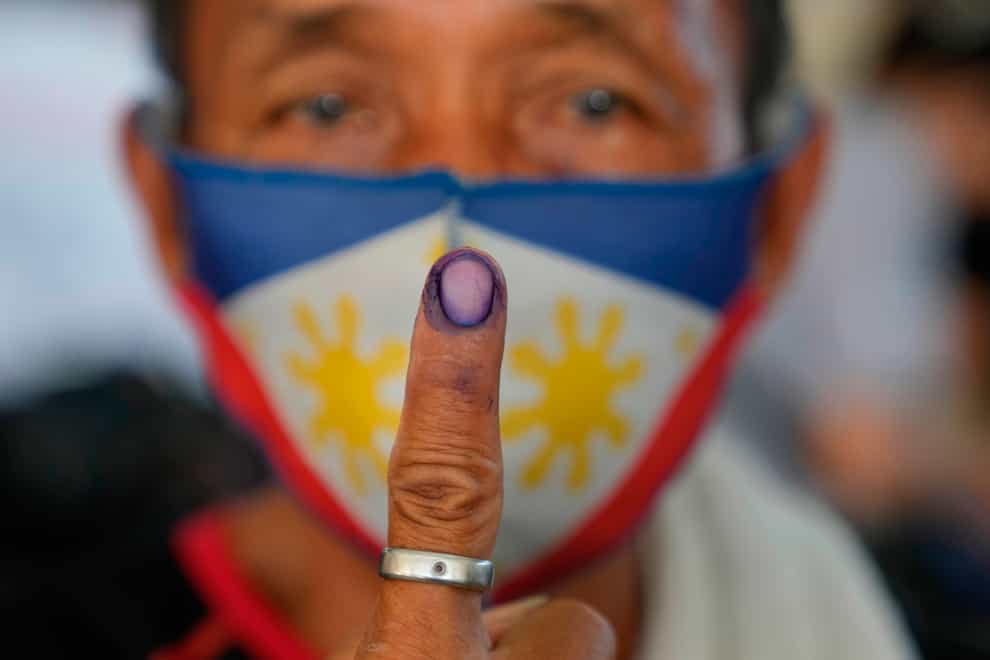 A man shows ink on his finger to show he has finished voting during the elections (AP)