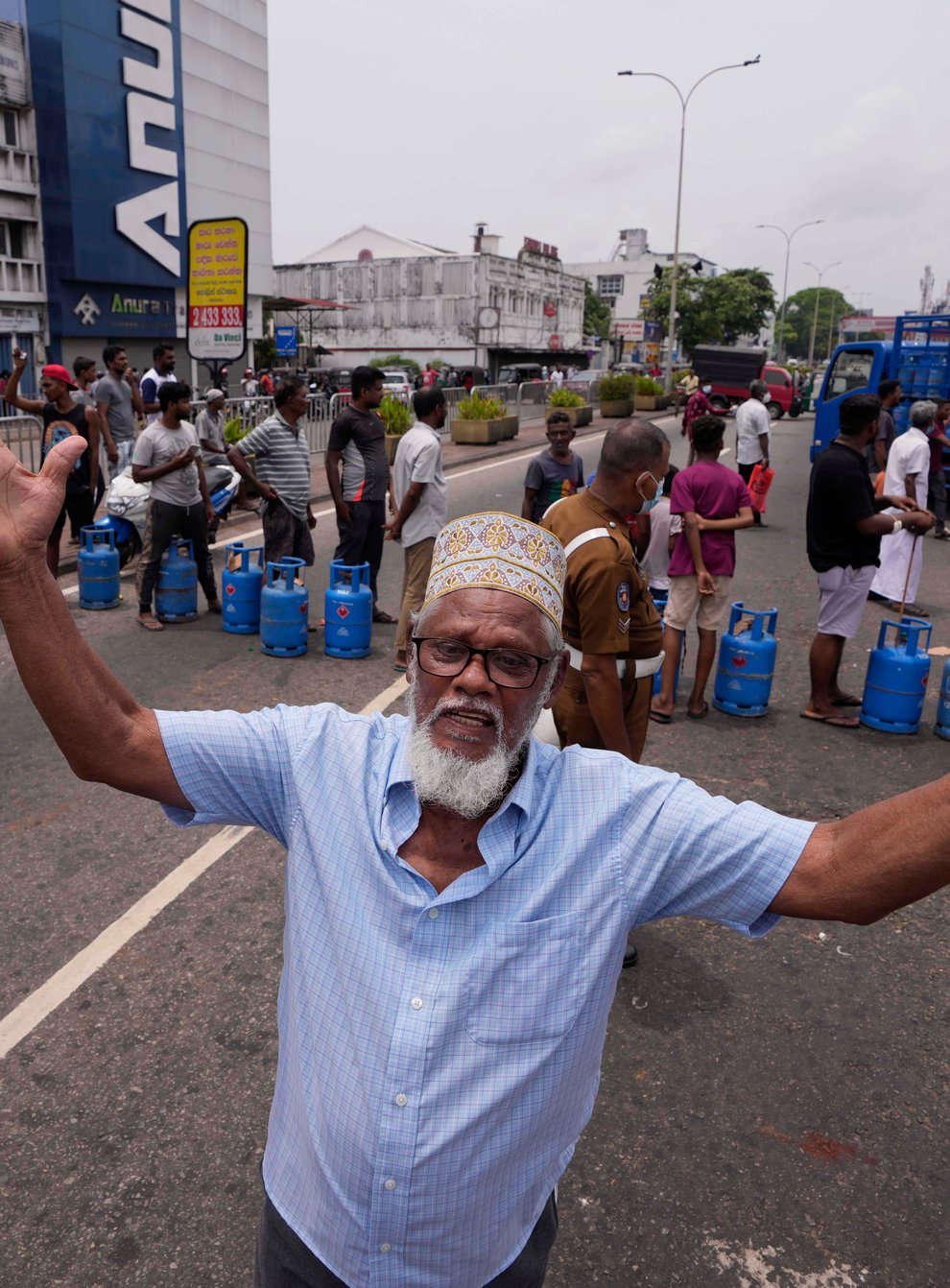 A Sri Lankan man shouts in jubilation after a truck carrying cooking gas arrived at a distribution centre in Colombo, Sri Lanka, on Sunday May 8 2022 (Eranga Jayawardena/AP)