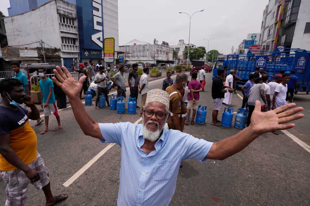 A Sri Lankan man shouts in jubilation after a truck carrying cooking gas arrived at a distribution centre in Colombo, Sri Lanka, on Sunday May 8 2022 (Eranga Jayawardena/AP)