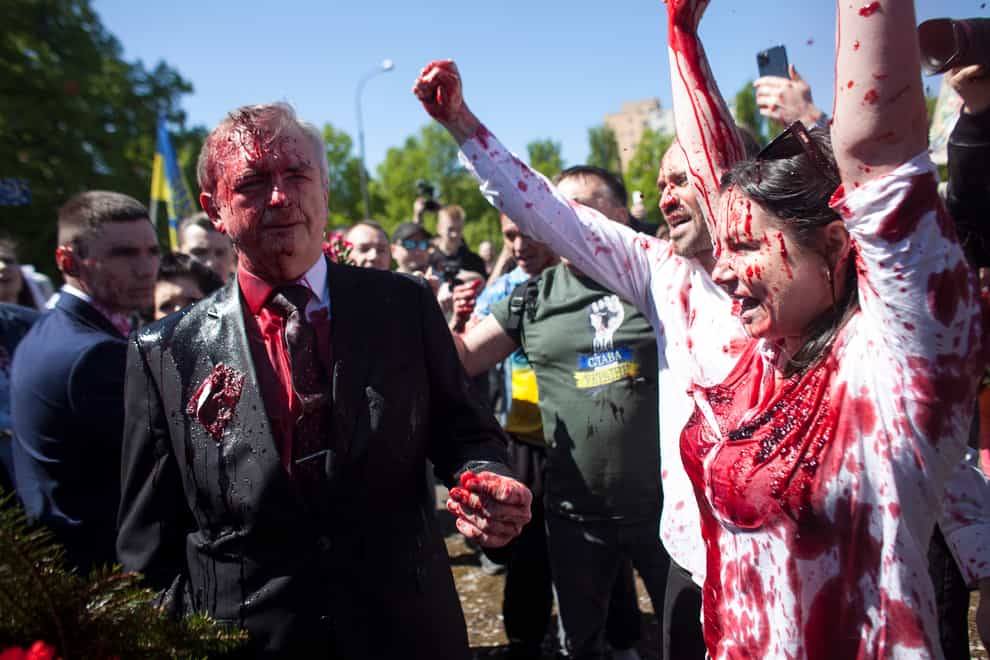 Activists shout slogans as Russian ambassador to Poland, Sergey Andreev, left, is covered with red paint in Warsaw, Poland, on Monday May 9 2022 (Maciek Luczniewski/AP)