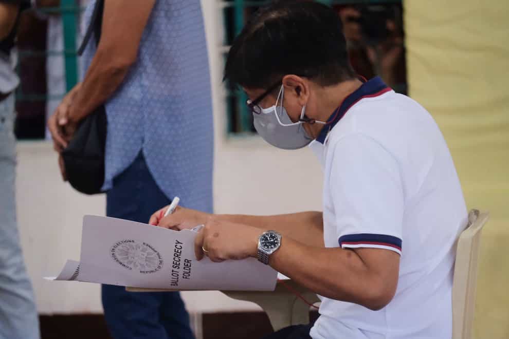 Presidential candidate Ferdinand Marcos Jnr, the son of the late dictator, votes at a polling centre in Batac City, Ilocos Norte, northern Philippines, on Monday May 9 2022 (AP)