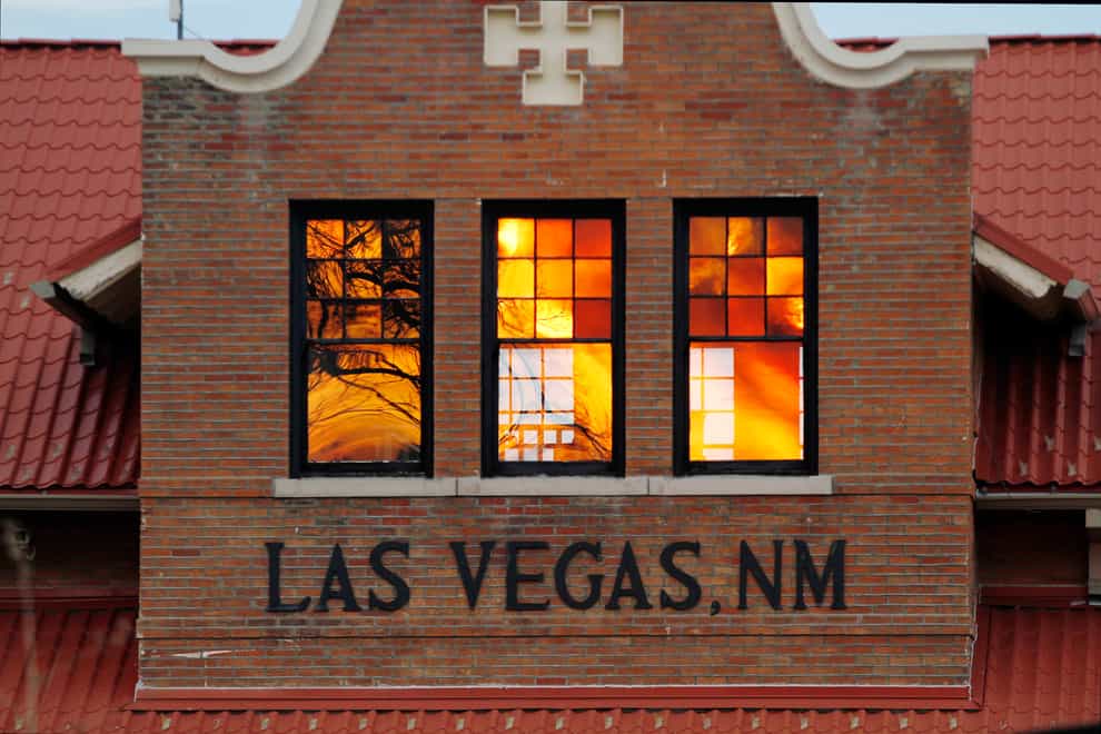 Reddened by wildfire smoke, the sun is seen reflected off windows at the train station in Las Vegas, New Mexico (Cedar Attanasio/AP)