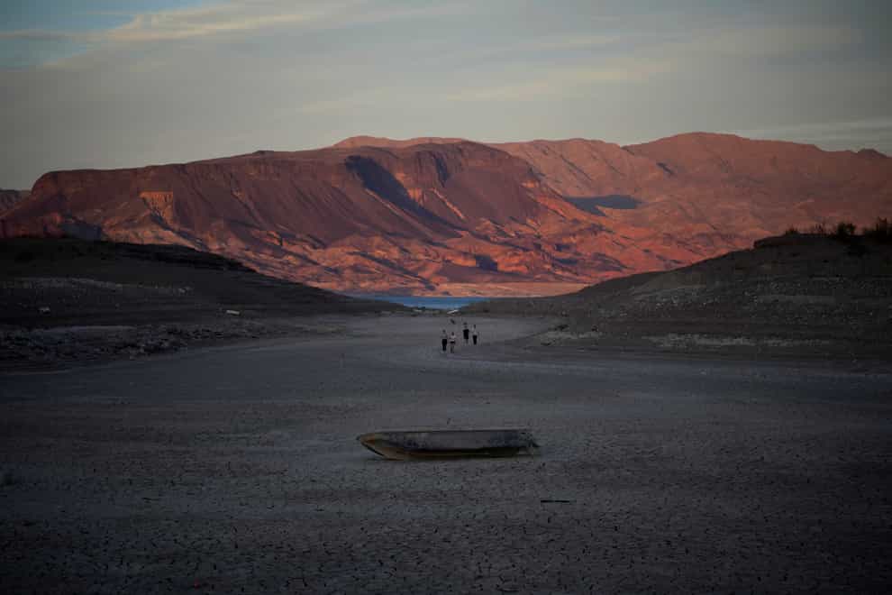 A formally sunken boat sits on cracked earth at Lake Mead (John Locher/AP)