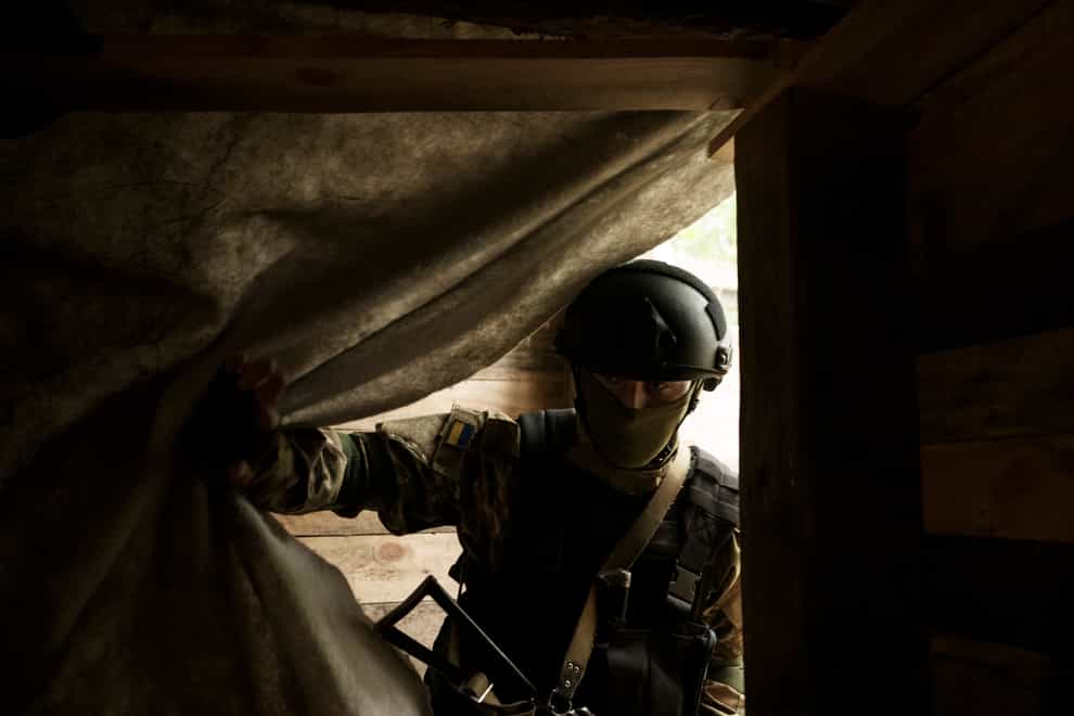 A Ukrainian National Guard soldier enters a underground shelter at a position near Kharkiv, Ukraine, on Monday May 9 2022 (Felipe Dana/AP)