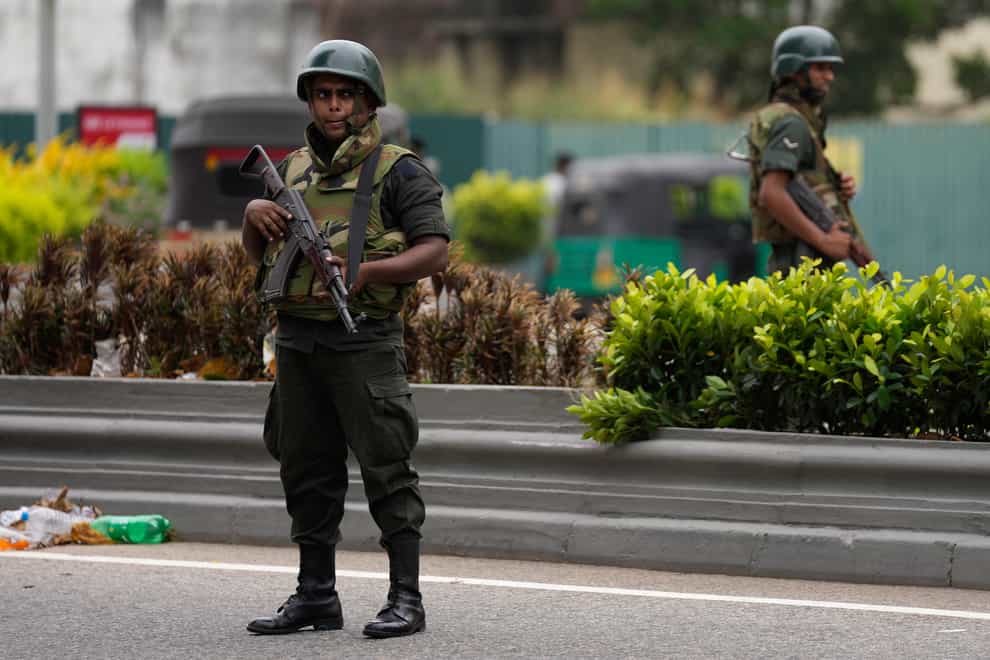 Sri Lankan troops stand guard outside the former prime minister’s residence a day after clashes between government supporters and anti-government protesters in Colombo (Eranga Jayawardena/AP)