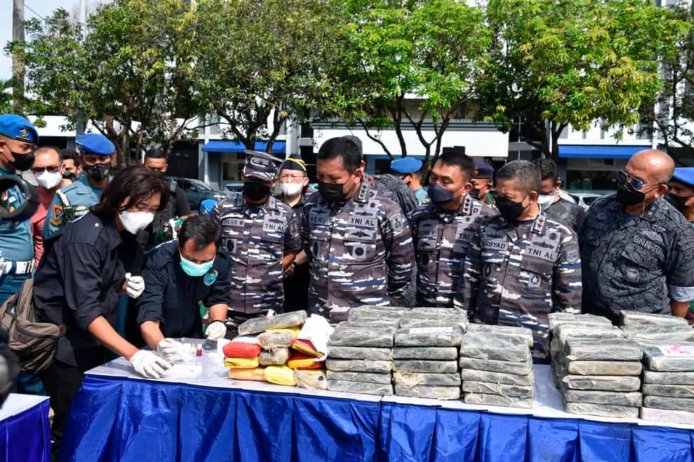 In this photo released by the Indonesian Navy, members of the National Narcotics Agency and Indonesian Navy officials check packages containing 179 kilograms (nearly 400 pounds) of cocaine worth 1.2 trillion rupiah ($82.6 million) during a media conference at the Western Fleet headquarters in Jakarta, Indonesia, Monday, May 9, 2022. Sailors deployed to secure travel during the Eid al-Fitr holiday made the country’s biggest cocaine seizure so far after finding the plastic packages of the drugs floating at sea, the navy said. (Indonesian Navy via AP)